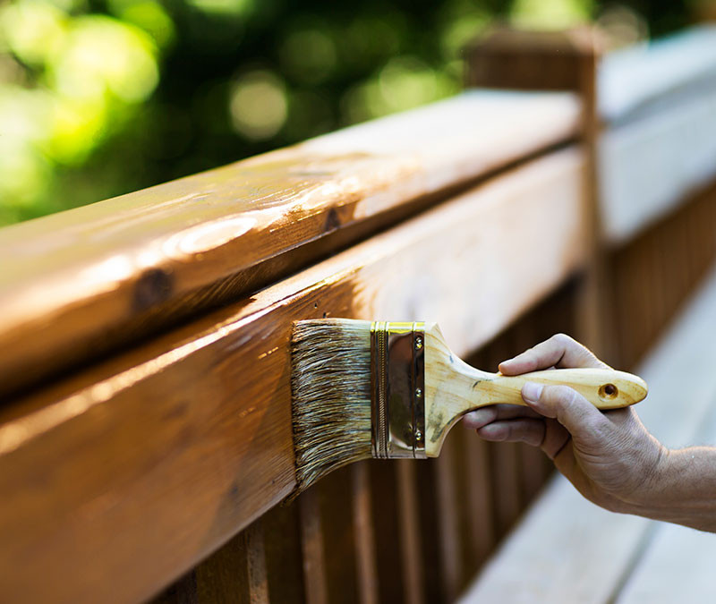 brushing-stain-on-wood-railing